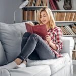 Woman reading under soft lighting from a flexible fan floor light.