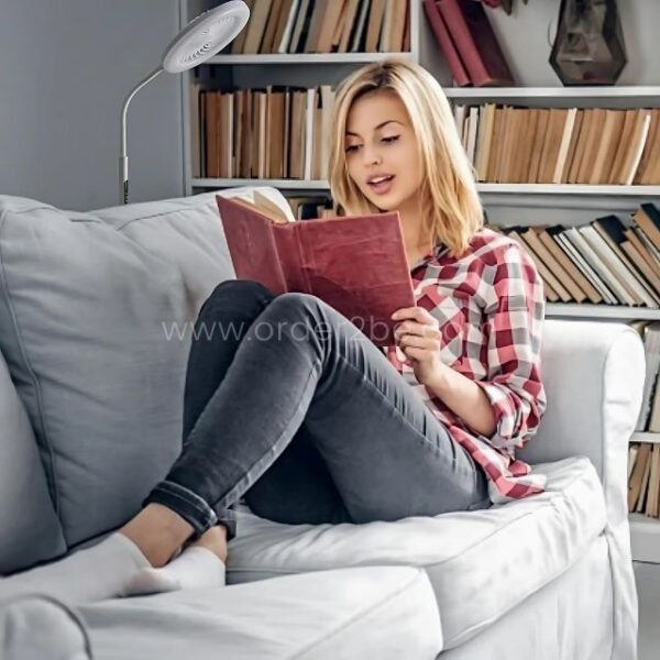 Woman reading under soft lighting from a flexible fan floor light.