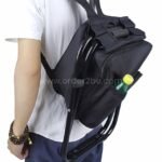 A black portable backpack chair worn on a man's back.