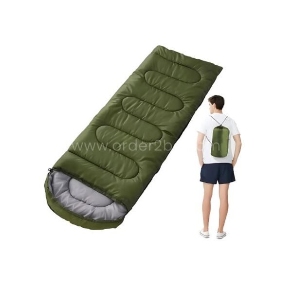 Green portable sleeping bag on a white background beside a standing person with a backpack, highlighting its compact size.