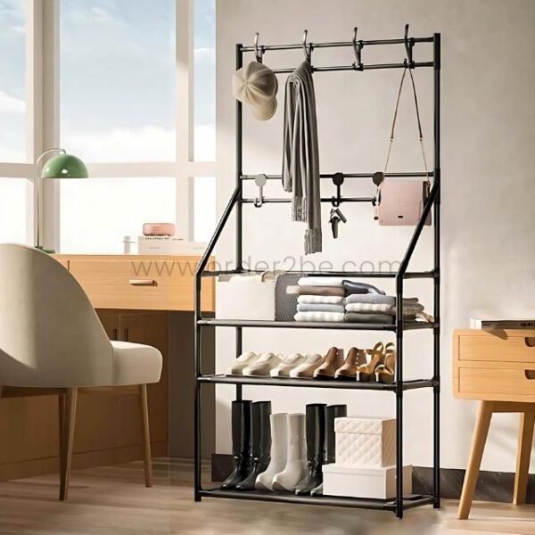 Black entryway shoe rack with coats, bags, keys, and shoes near window in bright room.