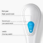 Close-up of electric shower brush control panel with on/off and two speed settings.