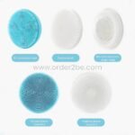 Five interchangeable shower brush heads laid flat, including silicone, bubble, microdermabrasion, and foaming types.