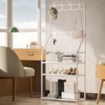 White entryway rack with shoes, folded clothes, and handbag in bright living space.